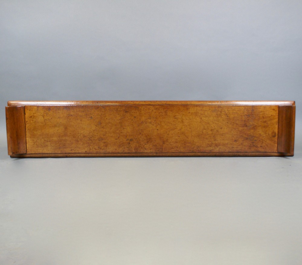 An antique wooden window seat with fluted turned legs and scroll ends on a neutral background. View VII