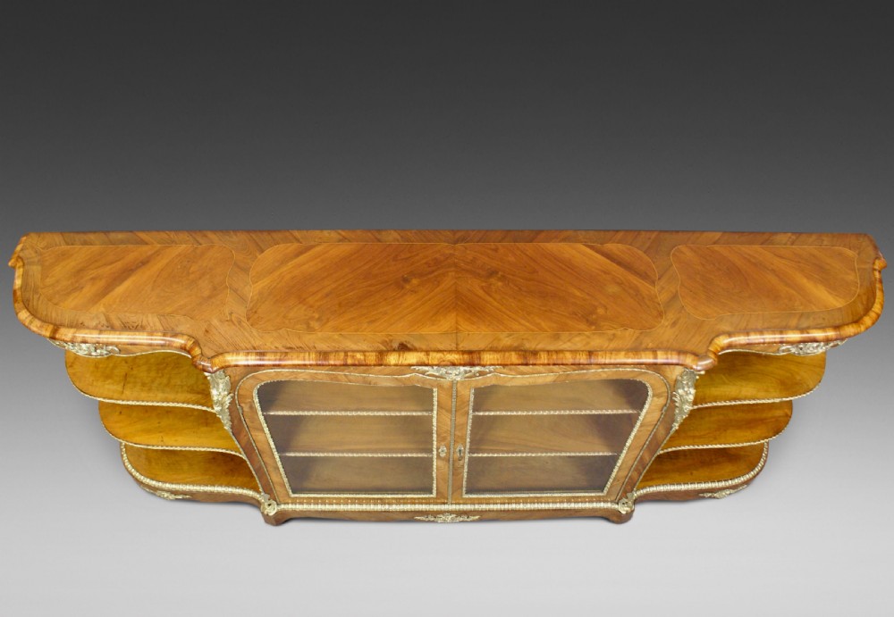 An antique walnut side cabinet featuring central glazed double doors flanked by open curved side shelves and gilt-bronze mounts. View II