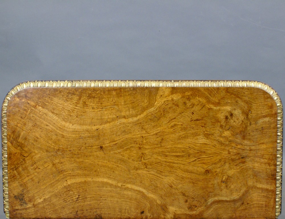 A Victorian walnut card table featuring gilt leaf moulding, a fold-over top, and a carved scrollwork pedestal base. View V