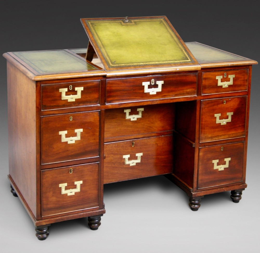 Mid-19th century mahogany military pedestal desk featuring brass flush handles, multiple drawers, and a green leather insert with a raised central writing slope.