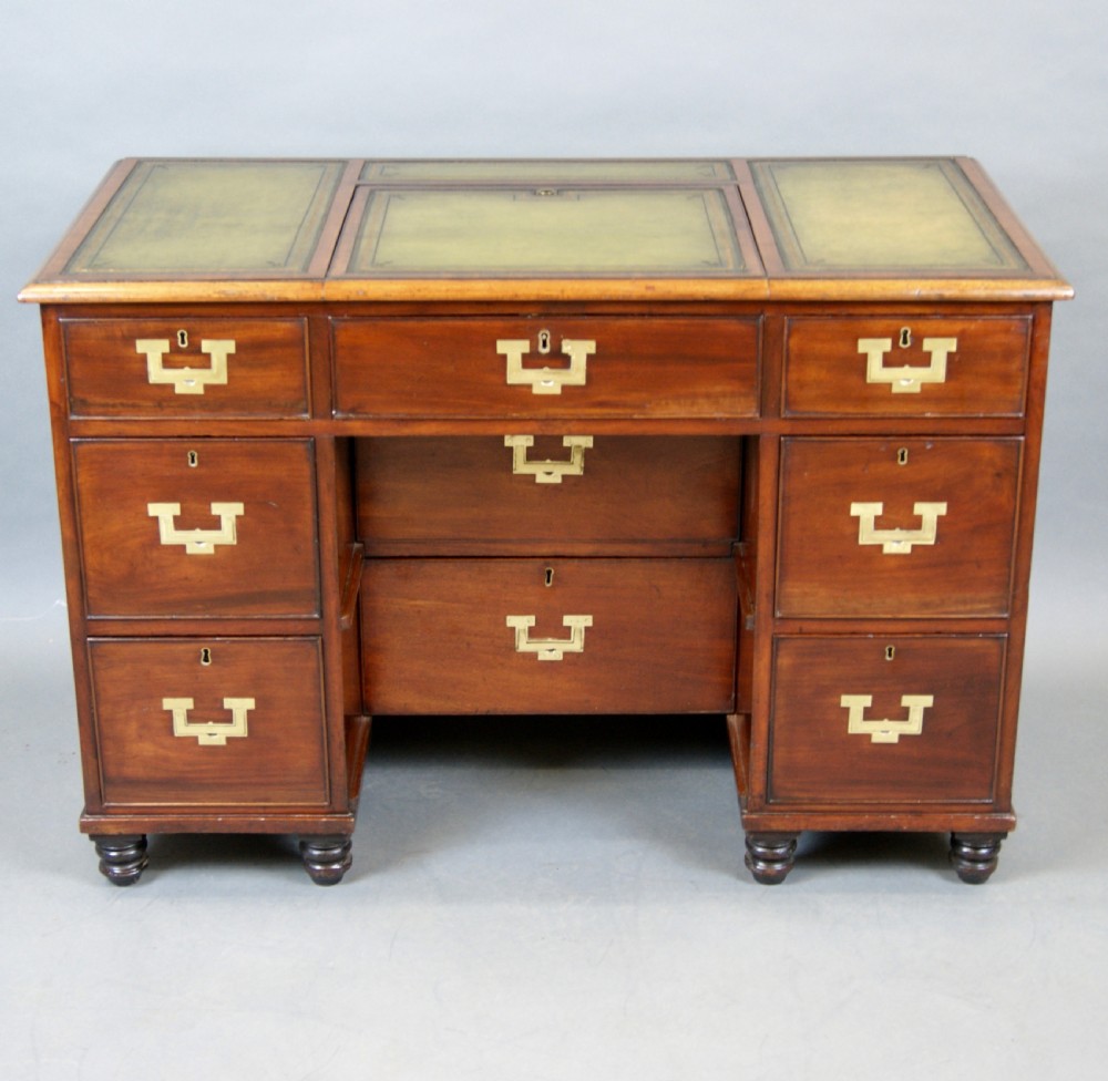 Mid-19th century mahogany military pedestal desk featuring brass flush handles, multiple drawers, and a green leather insert with a raised central writing slope. View II