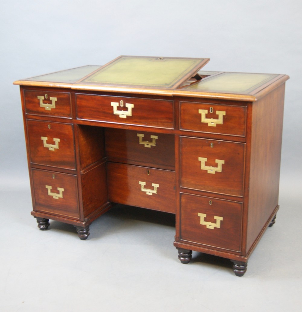 Mid-19th century mahogany military pedestal desk featuring brass flush handles, multiple drawers, and a green leather insert with a raised central writing slope. View VII