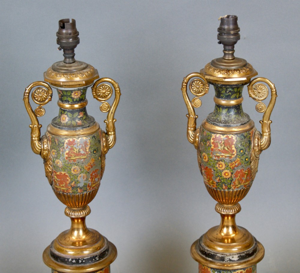 A pair of French classical urn-shaped toleware table lamps featuring hand-painted floral decoration, gilded scroll handles, octagonal pedestals, and pleated cream shades. View III