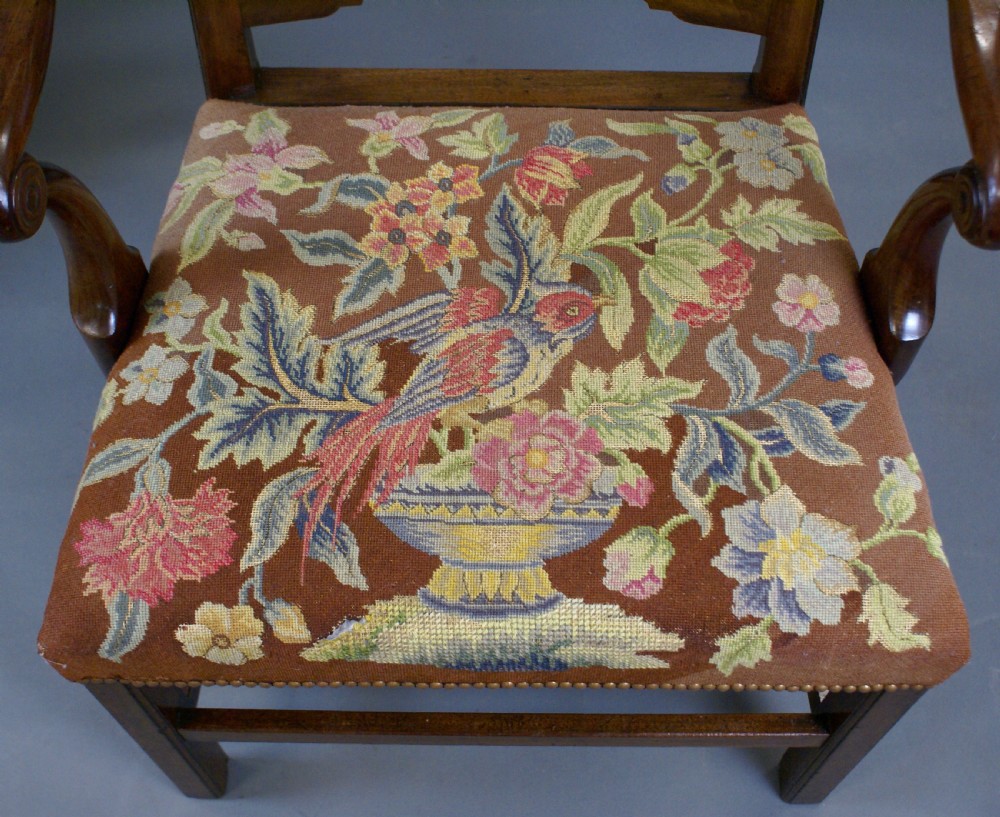 A pair of mahogany Chippendale ladderback armchairs with curved open arms and floral needlepoint seats. View IV