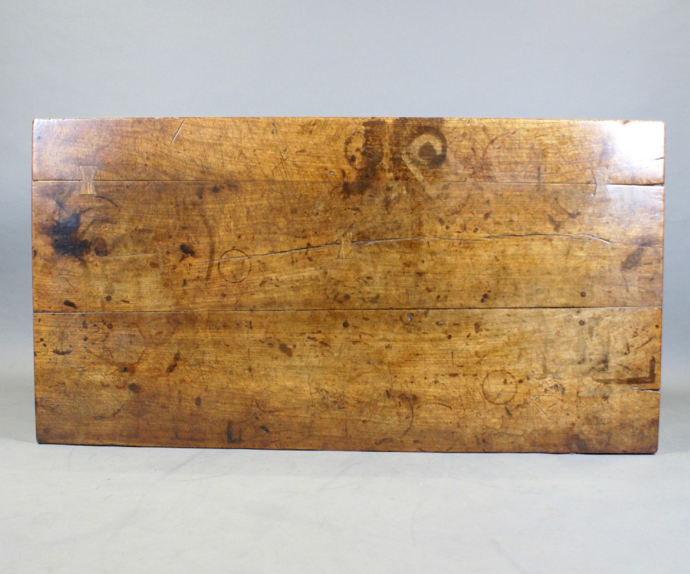 A nineteenth-century carved walnut refectory table with a thick wooden top resting on heavily carved trestle supports and a low stretcher. View II