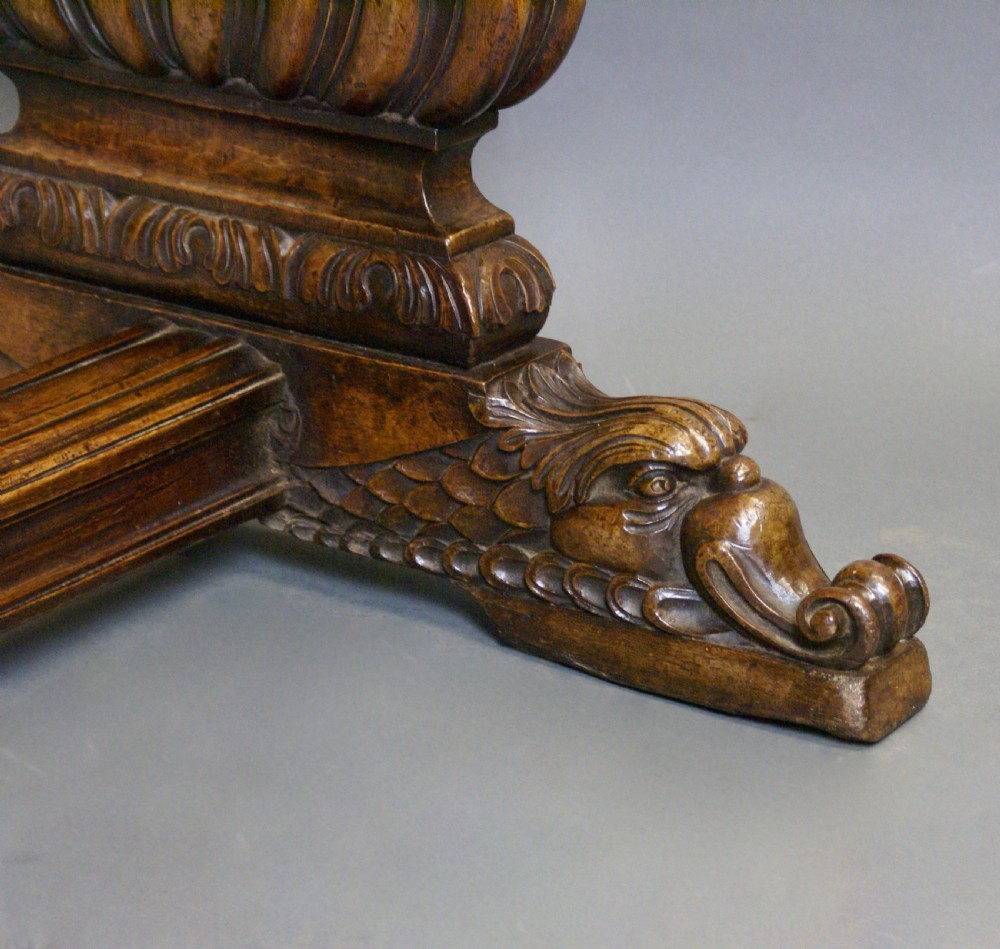 A nineteenth-century carved walnut refectory table with a thick wooden top resting on heavily carved trestle supports and a low stretcher. View VI