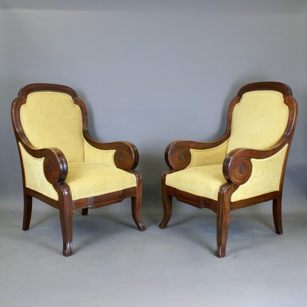 A pair of antique mahogany library armchairs featuring bold scroll arms and yellow fabric upholstery. View III