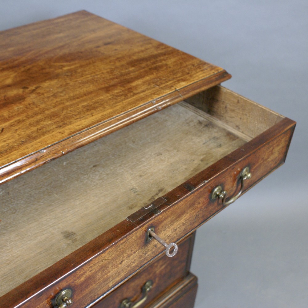 A Georgian mahogany chest of drawers featuring four graduated drawers with brass swan-neck handles and bracket feet. View VI