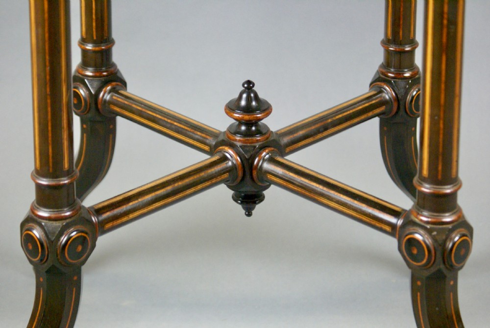 An octagonal dark rosewood occasional table featuring foliate marquetry inlays around the border, turned supports, a cross-stretcher, and splayed legs with brass castors. View III