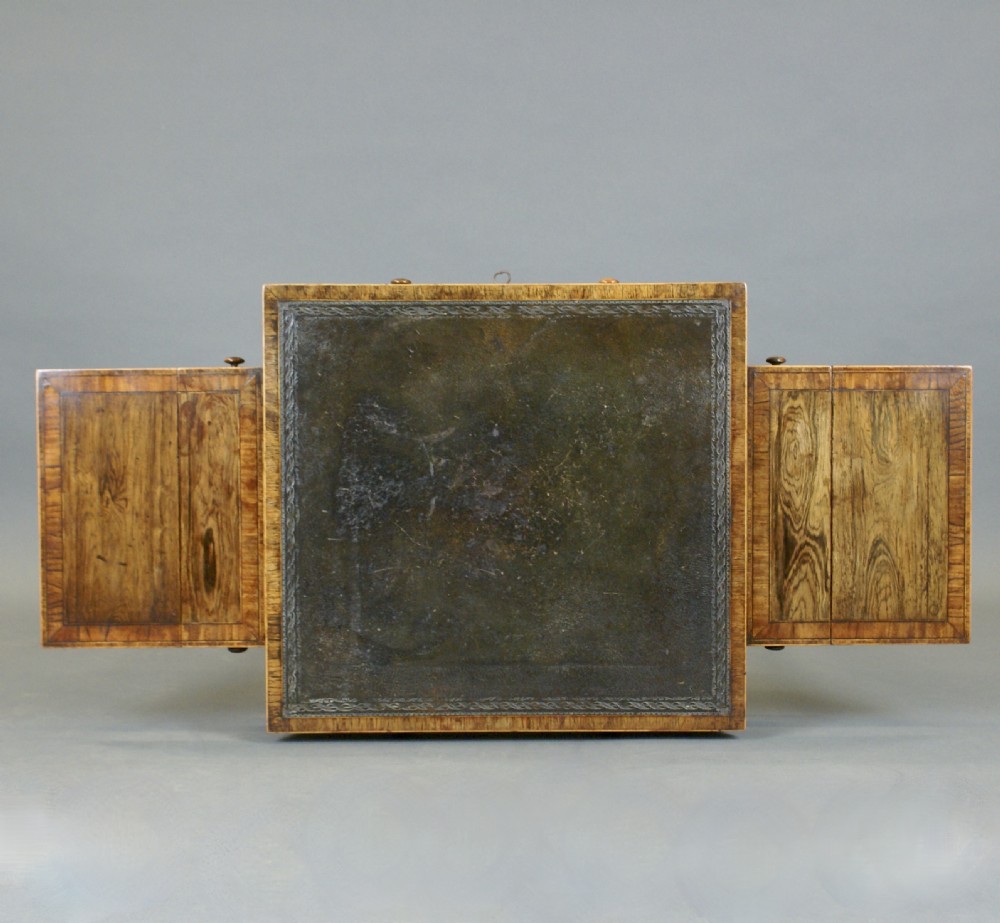 A small Regency rosewood writing table with a dark leather inset top, two drop flaps, a frieze drawer, and slender twin supports on splayed feet. View II