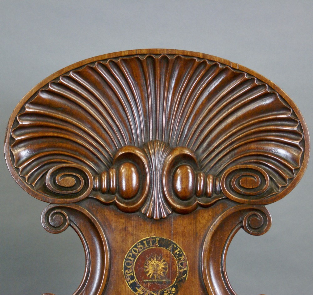 A pair of carved mahogany hall chairs featuring scalloped shell backs with painted crests and reeded front legs. View II