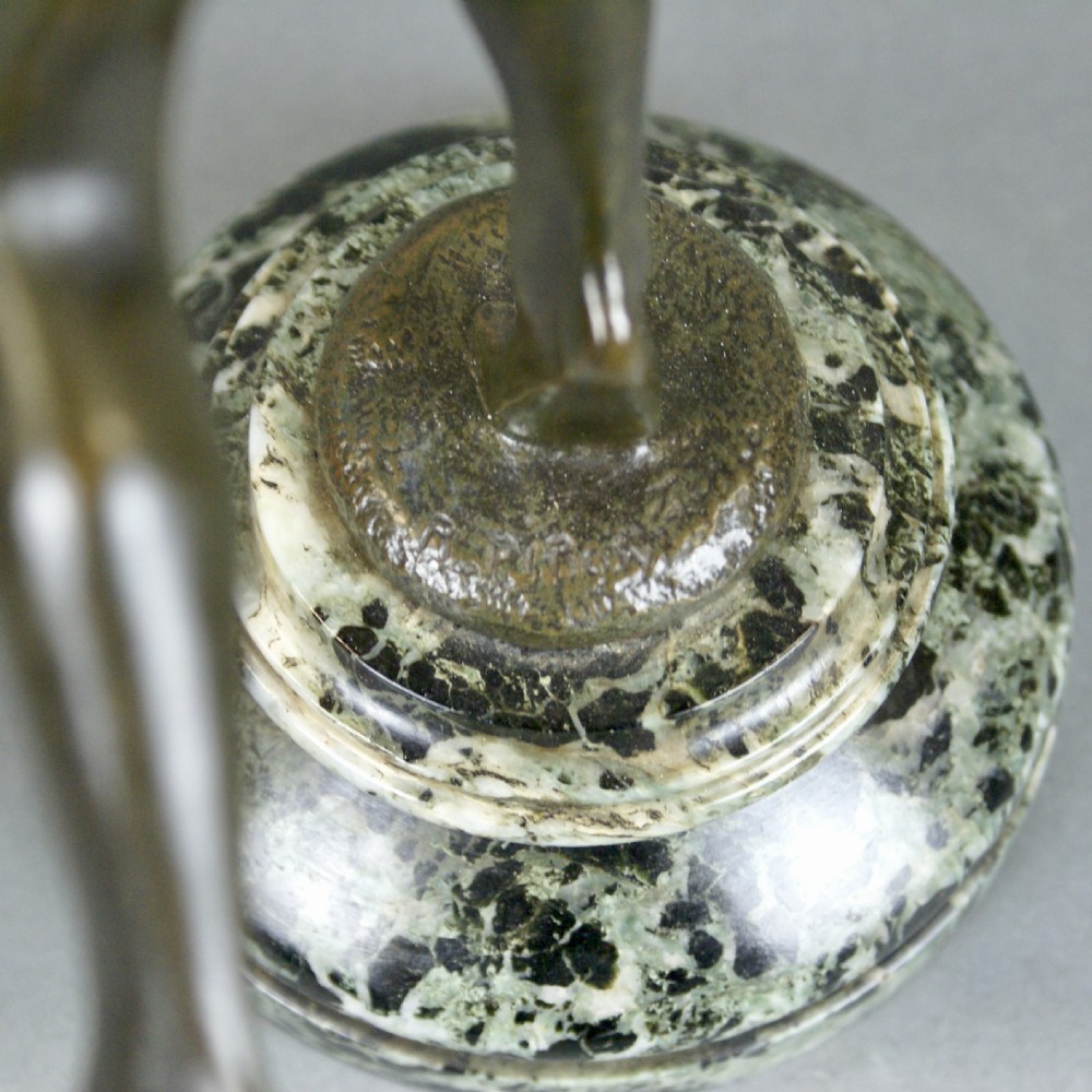 A patinated bronze sculpture of a dancing female figure holding a tambourine aloft, mounted on a round marble base. View VII