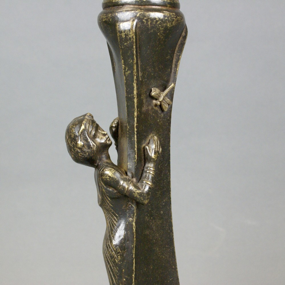 An Art Nouveau patinated bronze table lamp featuring a sculptural figure reaching towards a dragonfly on a flared stem, topped with a white conical shade. View II