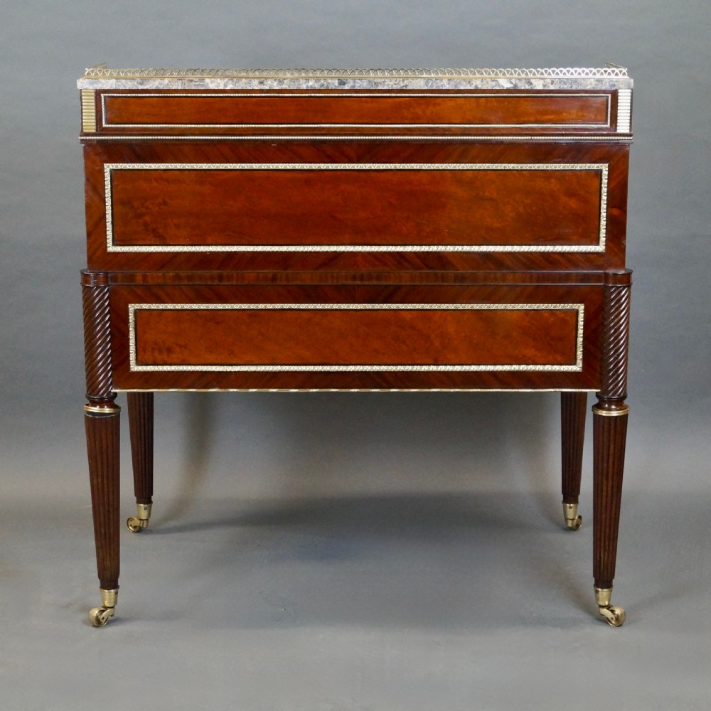 A Regency mahogany cylinder desk featuring a marble top with a brass gallery, brass-inlaid drawers, reeded tapered legs, and brass castors. View V