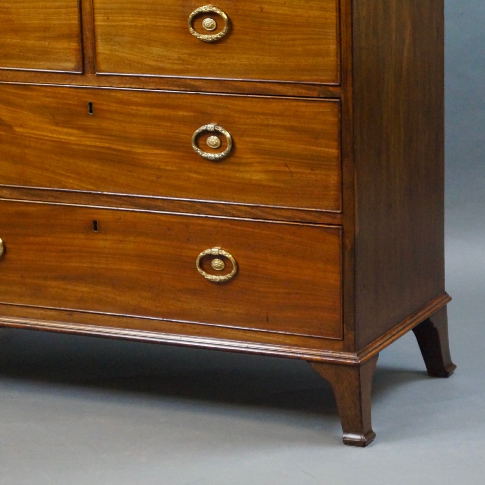 An antique mahogany secretaire chest of drawers featuring brass oval backplate handles, cockbeaded drawer edges, and bracket feet. View VII
