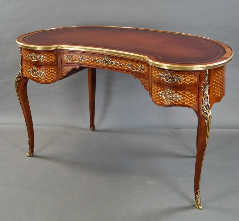 A French Louis XV style kidney-shaped writing desk featuring a brown leather top, parquetry veneer, gilded mounts, and cabriole legs. View II