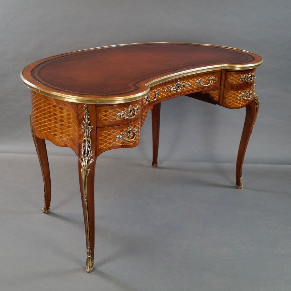 A French Louis XV style kidney-shaped writing desk featuring a brown leather top, parquetry veneer, gilded mounts, and cabriole legs. View V