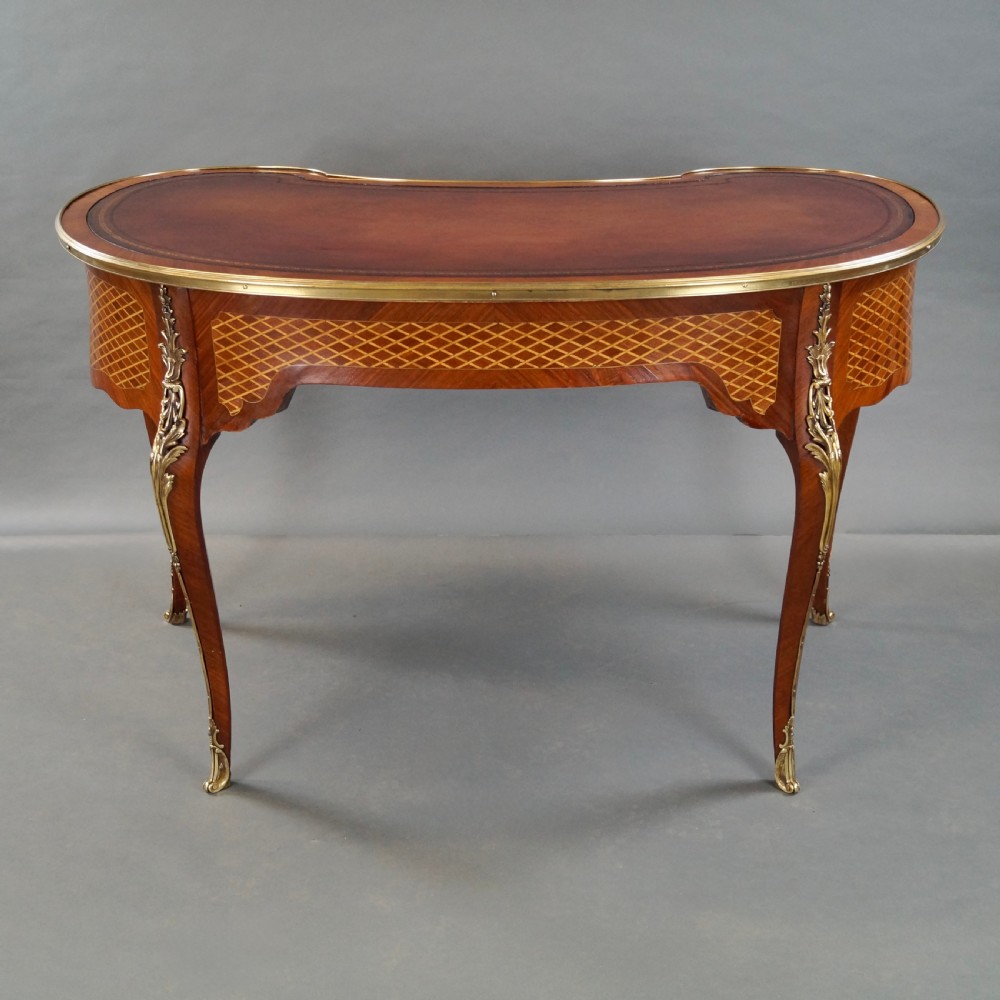 A French Louis XV style kidney-shaped writing desk featuring a brown leather top, parquetry veneer, gilded mounts, and cabriole legs. View VI