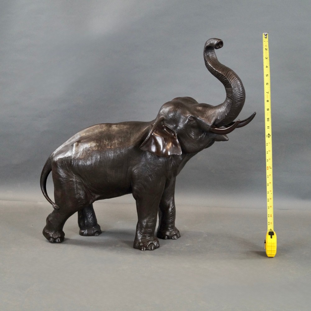 A cast bronze sculpture of an elephant standing with its trunk raised high, created in the Japanese Meiji style. View II