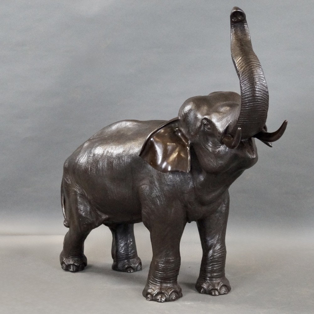 A cast bronze sculpture of an elephant standing with its trunk raised high, created in the Japanese Meiji style. View III