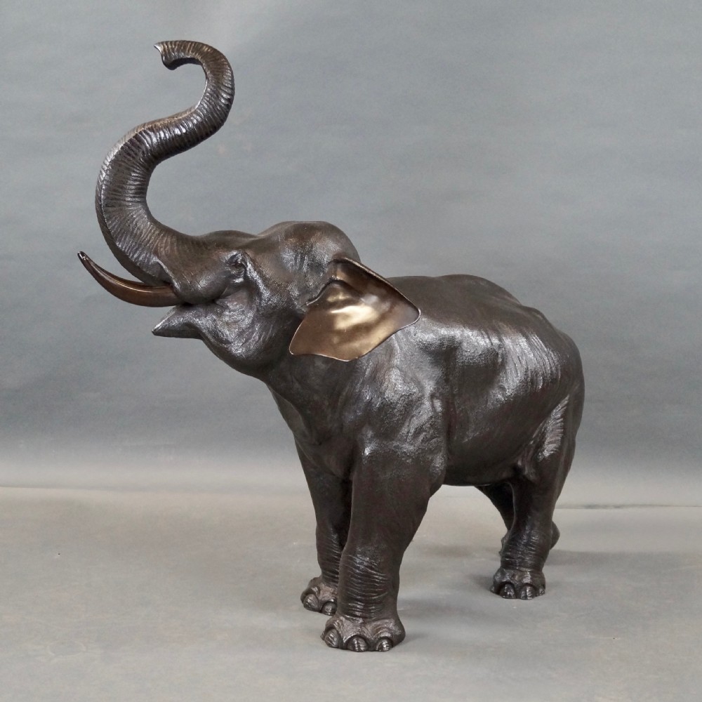 A cast bronze sculpture of an elephant standing with its trunk raised high, created in the Japanese Meiji style. View VII