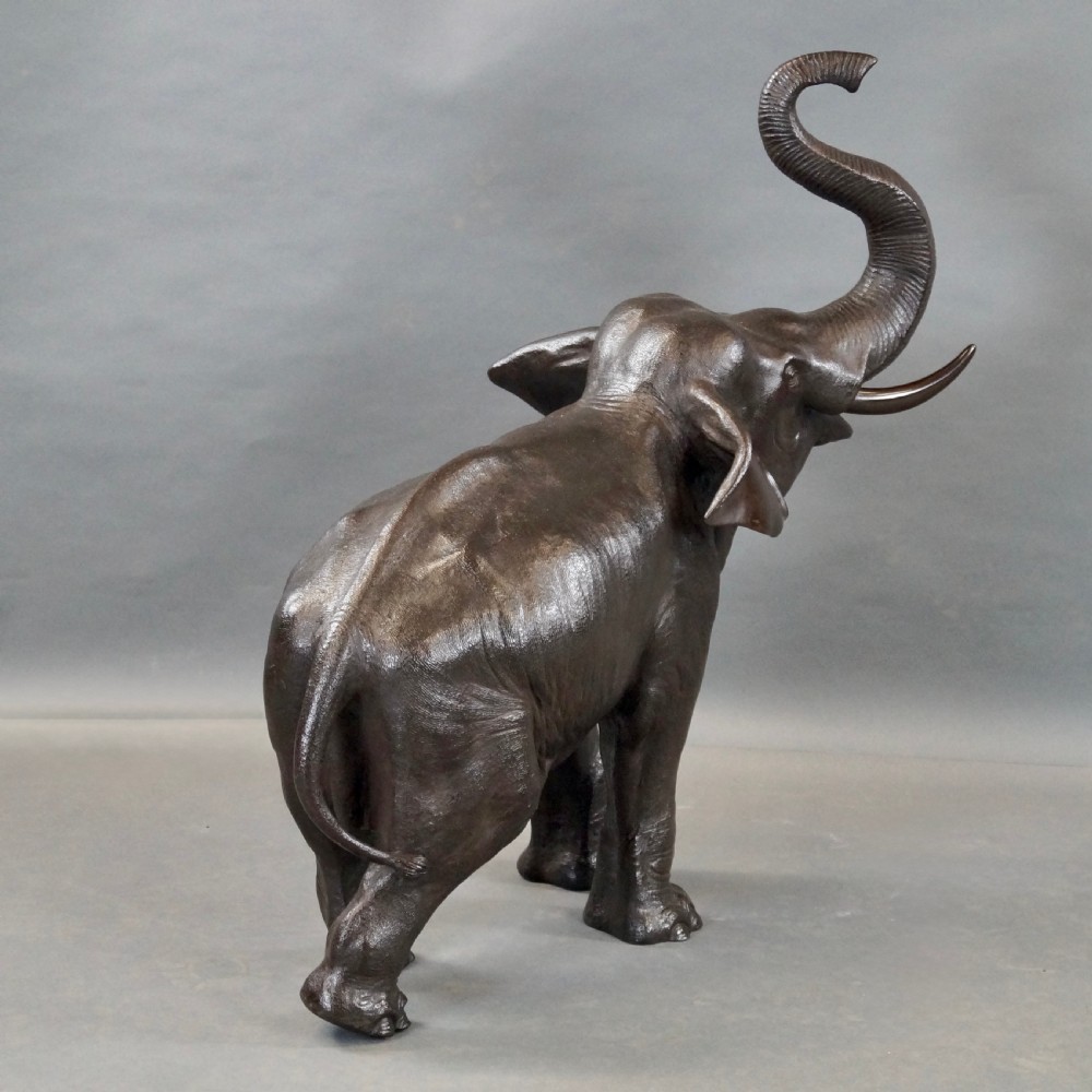 A cast bronze sculpture of an elephant standing with its trunk raised high, created in the Japanese Meiji style. View VIII
