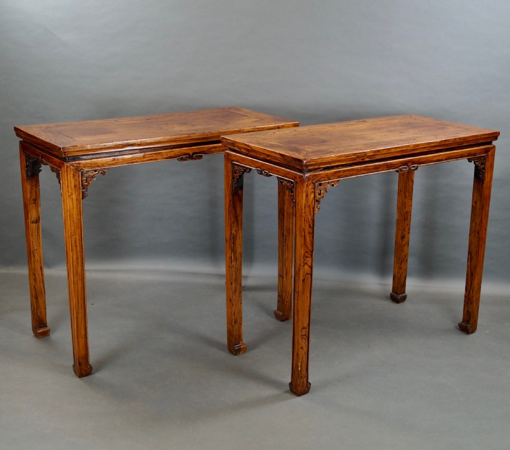 A pair of 19th-century Chinese elm side tables featuring rectangular floating panel tops, carved corner spandrels, and tall straight legs. View II
