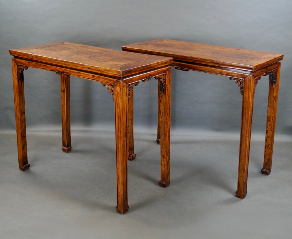 A pair of 19th-century Chinese elm side tables featuring rectangular floating panel tops, carved corner spandrels, and tall straight legs. View VI