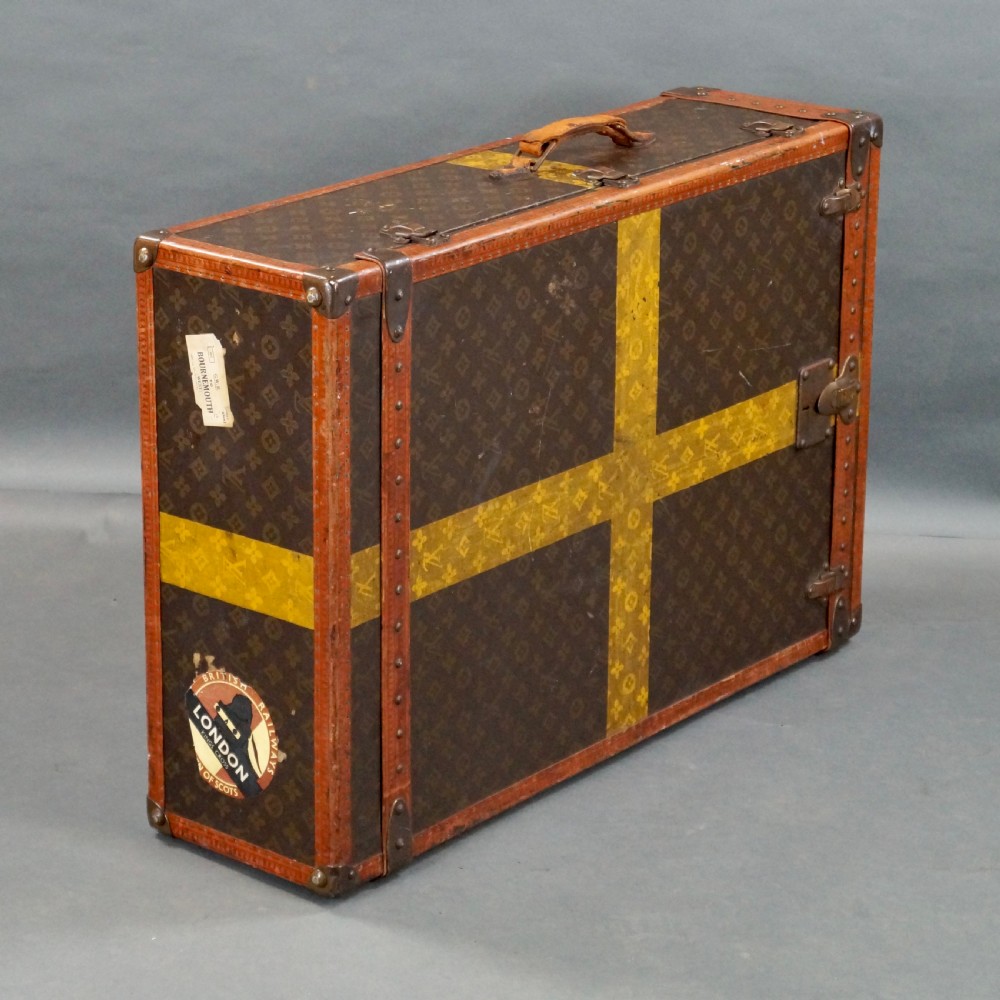 An upright 1930s Louis Vuitton monogram canvas wardrobe trunk featuring leather trim, brass hardware, and custom yellow painted stripes. View III