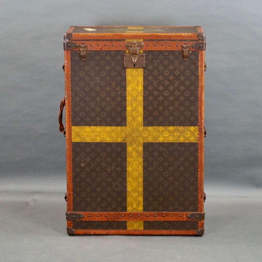 An upright 1930s Louis Vuitton monogram canvas wardrobe trunk featuring leather trim, brass hardware, and custom yellow painted stripes. View VIII