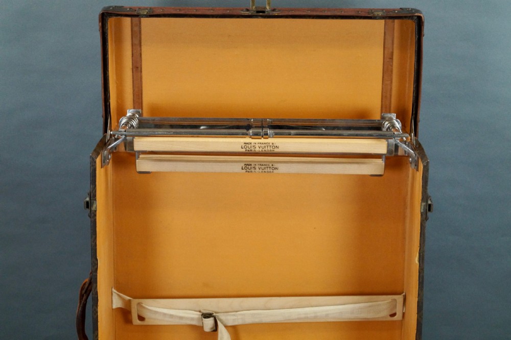 An upright 1930s Louis Vuitton monogram canvas wardrobe trunk featuring leather trim, brass hardware, and custom yellow painted stripes. View X