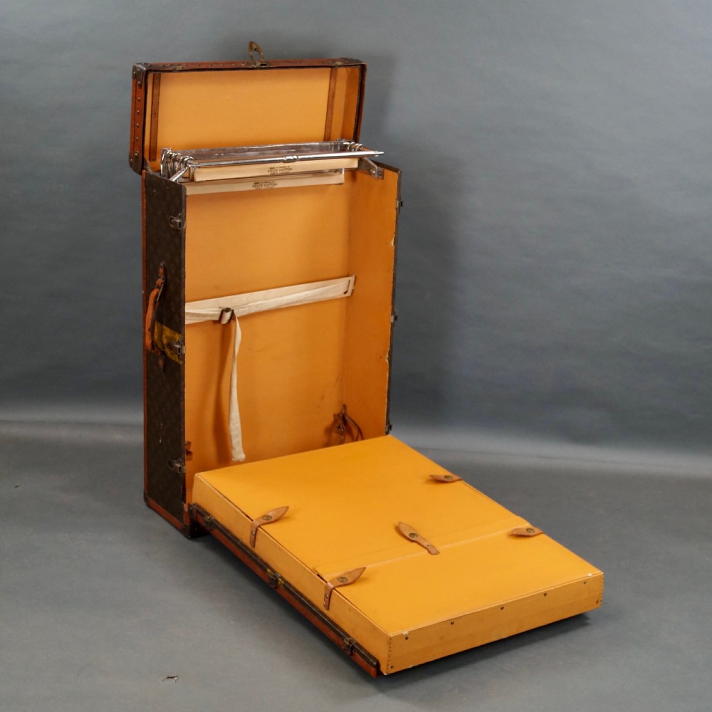 An upright 1930s Louis Vuitton monogram canvas wardrobe trunk featuring leather trim, brass hardware, and custom yellow painted stripes. View XII