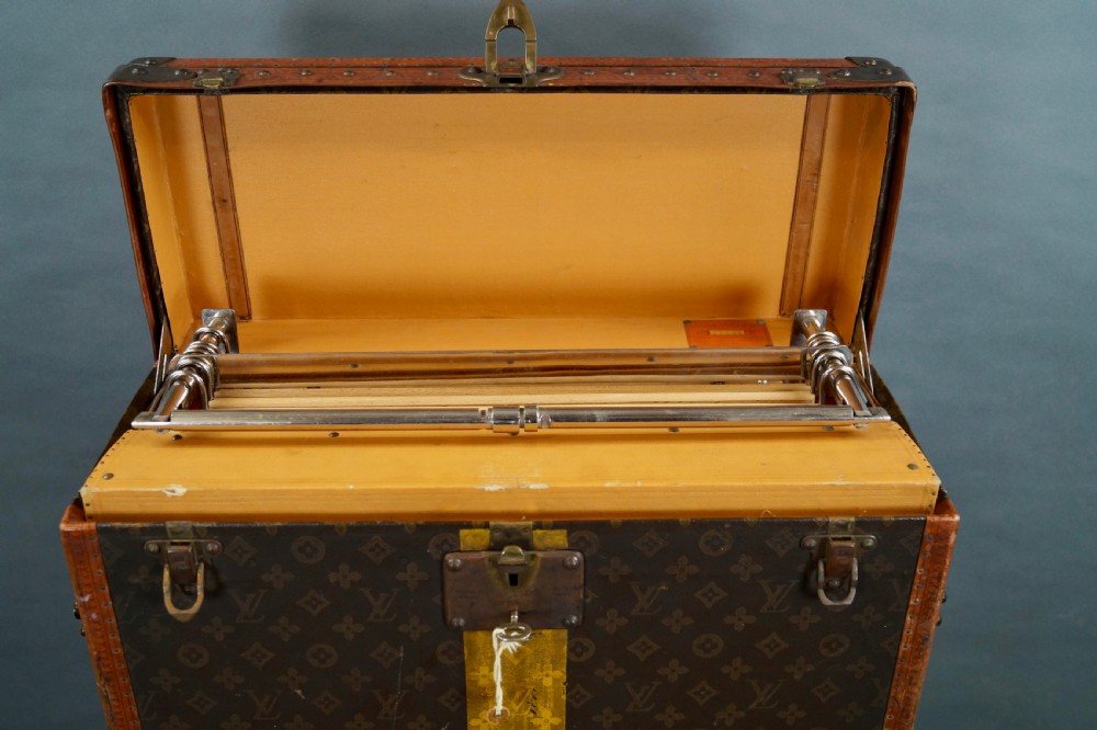 An upright 1930s Louis Vuitton monogram canvas wardrobe trunk featuring leather trim, brass hardware, and custom yellow painted stripes. View XIII