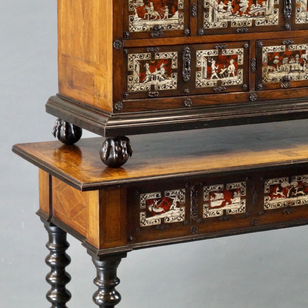 A 19th-century Portuguese cabinet on stand featuring inlaid bone figurative scenes, multiple drawer fronts surrounding a central arch, and a stand supported by dark spiral-turned legs. View VIII