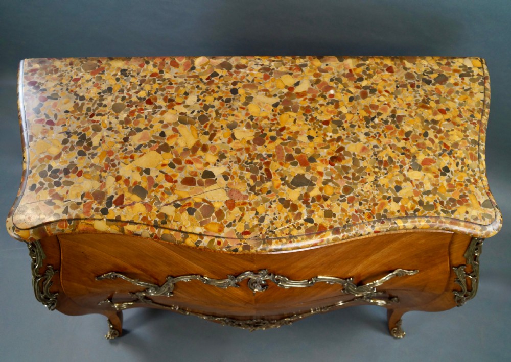 A nineteenth-century French bombe commode featuring chevron parquetry veneer, ornate scrollwork metal mounts, and a shaped marble top. View III