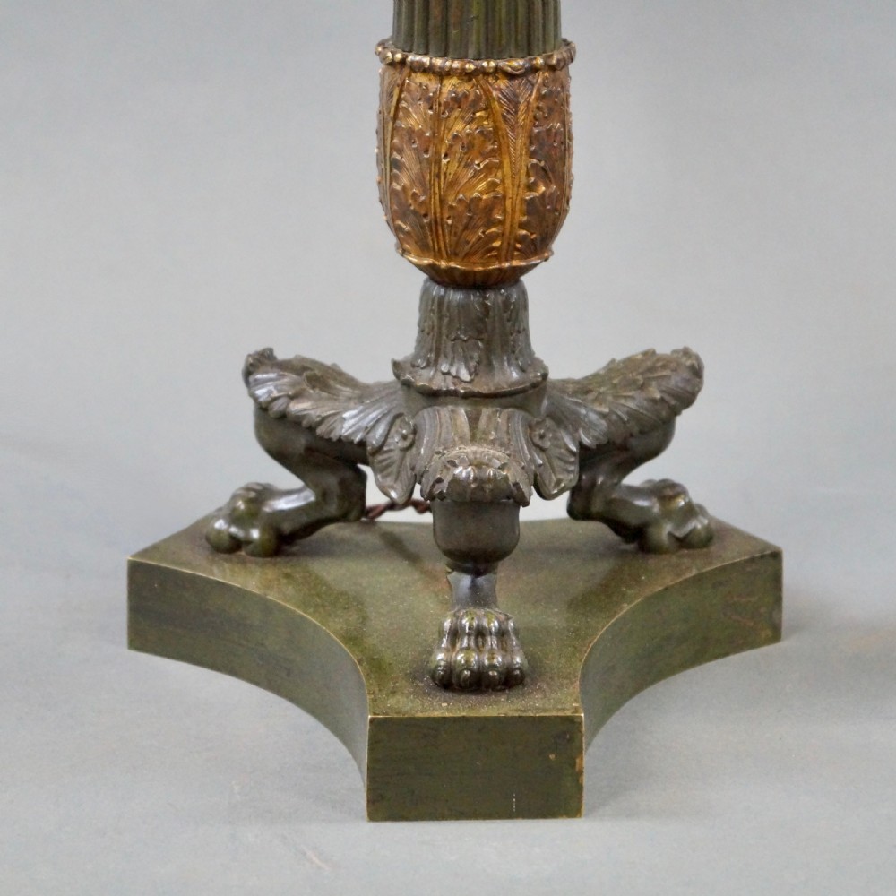 A pair of Neoclassical style dark patinated bronze table lamps featuring fluted columns, gilt bronze mounts, paw feet, and cream pleated shades. View III
