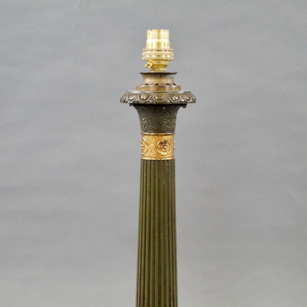 A pair of Neoclassical style dark patinated bronze table lamps featuring fluted columns, gilt bronze mounts, paw feet, and cream pleated shades. View V