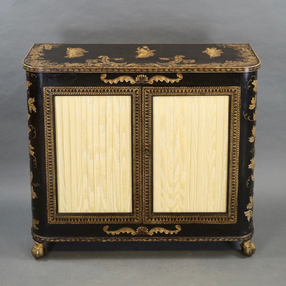 A Regency period black pen-work side cabinet featuring gold vine motifs, pleated yellow silk door panels, and gilded paw feet. View III