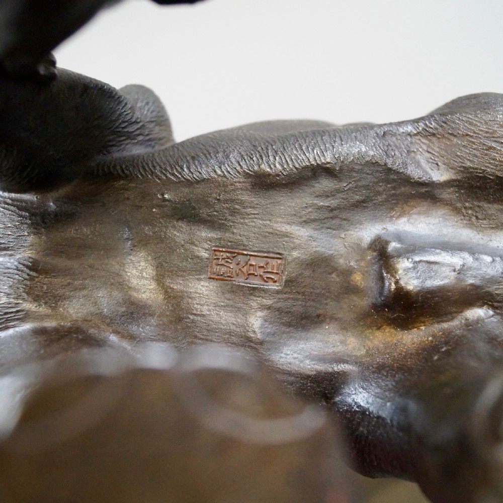 A dark brown patinated bronze okimono sculpture depicting an elephant fighting two tigers, featuring inlaid light tusks. View VIII