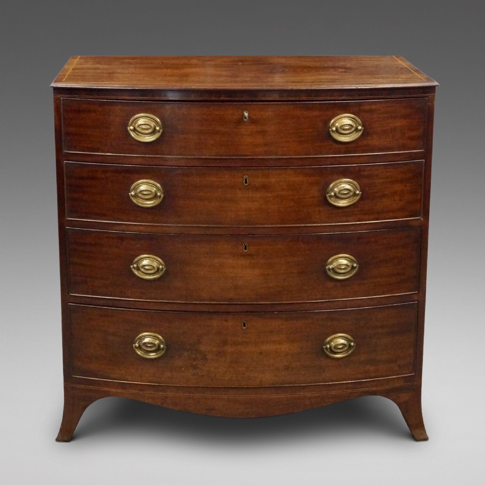 A George III mahogany bow-fronted chest featuring four graduated drawers with oval brass handles and splayed bracket feet.
