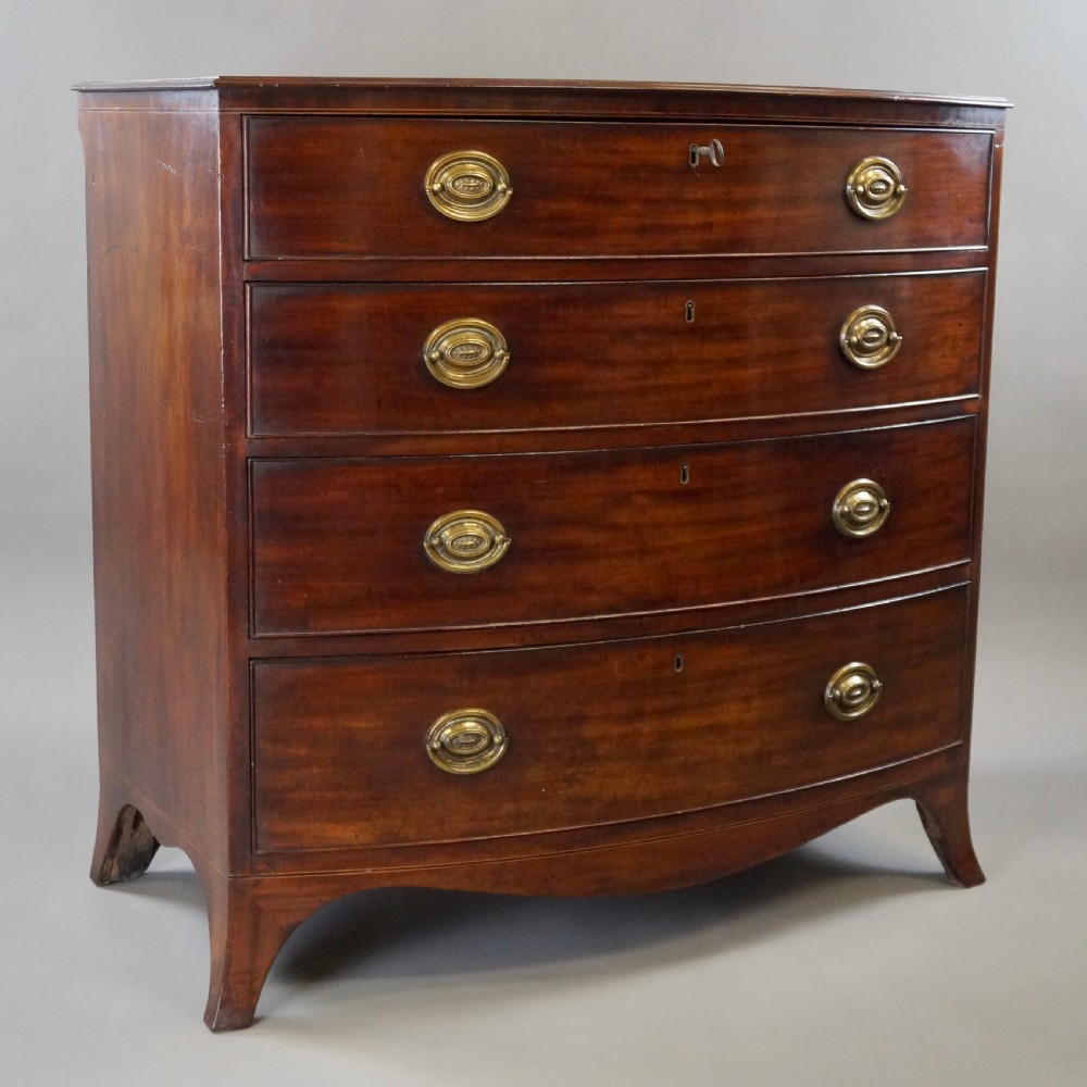 A George III mahogany bow-fronted chest featuring four graduated drawers with oval brass handles and splayed bracket feet. View III