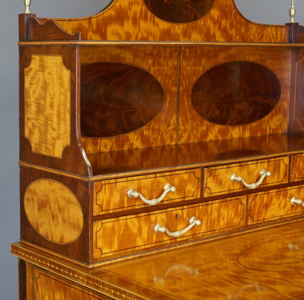 A satinwood bonheur du jour writing desk featuring oval marquetry medallions, a upper shelf superstructure, small drawers, and square tapered legs. View VIII