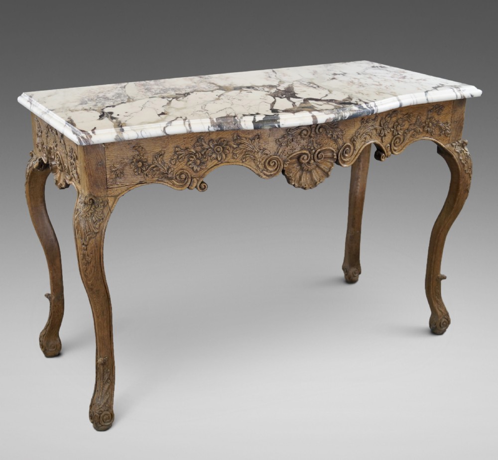 A late 18th-century carved oak console table with cabriole legs, a floral frieze, a shell motif, and a grey-veined white marble top.