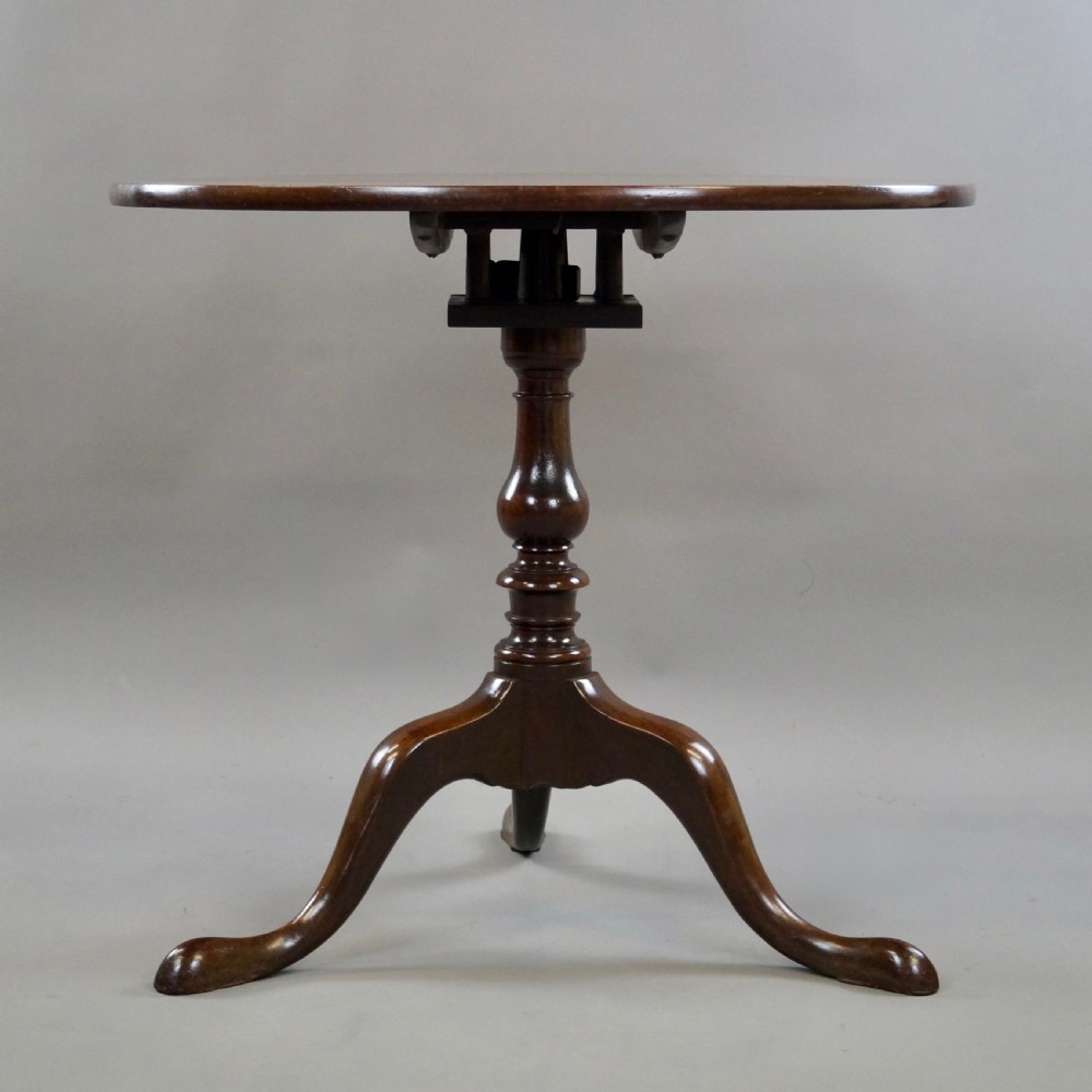 A George III mahogany tripod table featuring a circular tilt top supported by a turned central stem and three cabriole legs. View III