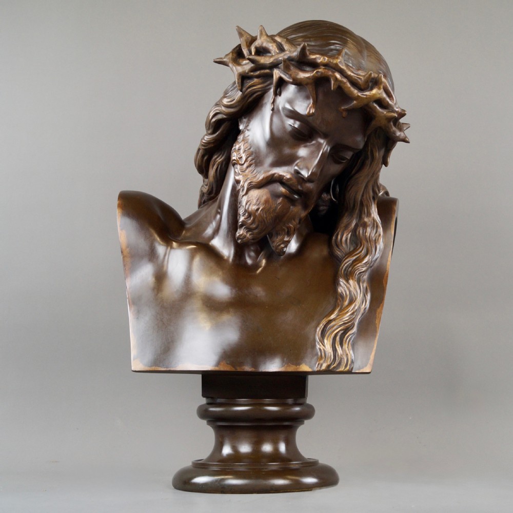 A large dark patinated bronze bust depicting Jesus Christ wearing the Crown of Thorns, mounted on a turned pedestal.
