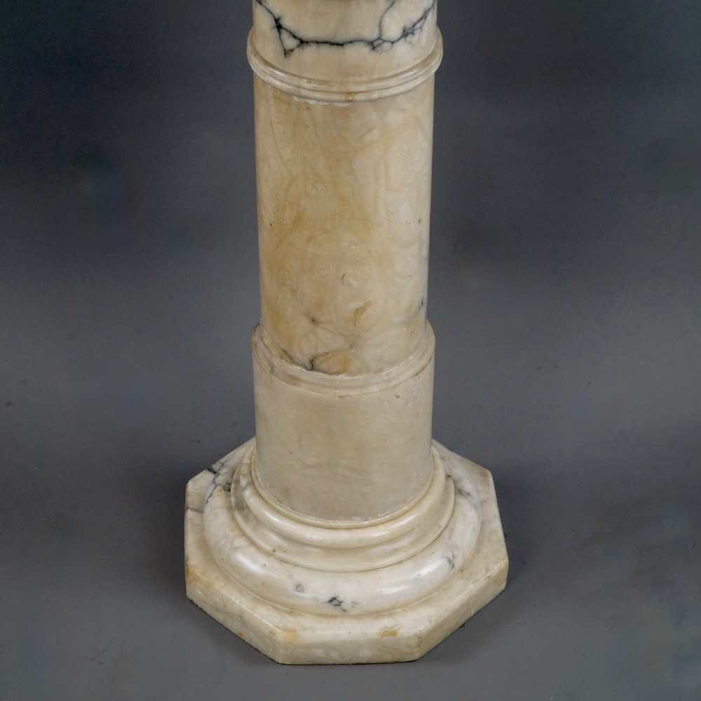 A Neoclassical Arabescato marble column featuring grey veining, a moulded square capital, a cylindrical shaft, and an octagonal base. View III