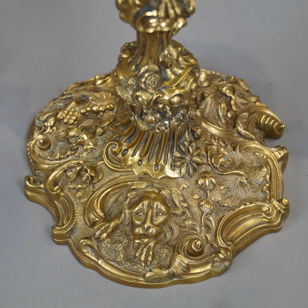 A pair of ornate French Rococo style ormolu three-light candelabra with scrolling leafy arms and intricate cast bases. View VI