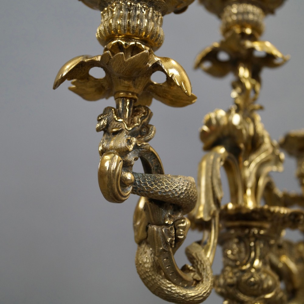 A pair of ornate French Rococo style ormolu three-light candelabra with scrolling leafy arms and intricate cast bases. View VII