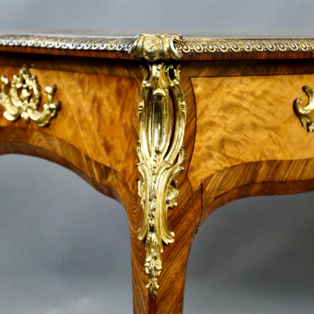 A pair of Louis XV style bureau plat writing desks featuring satinwood marquetry, green leather tops, cabriole legs, and elaborate gilt-bronze mounts. View IV