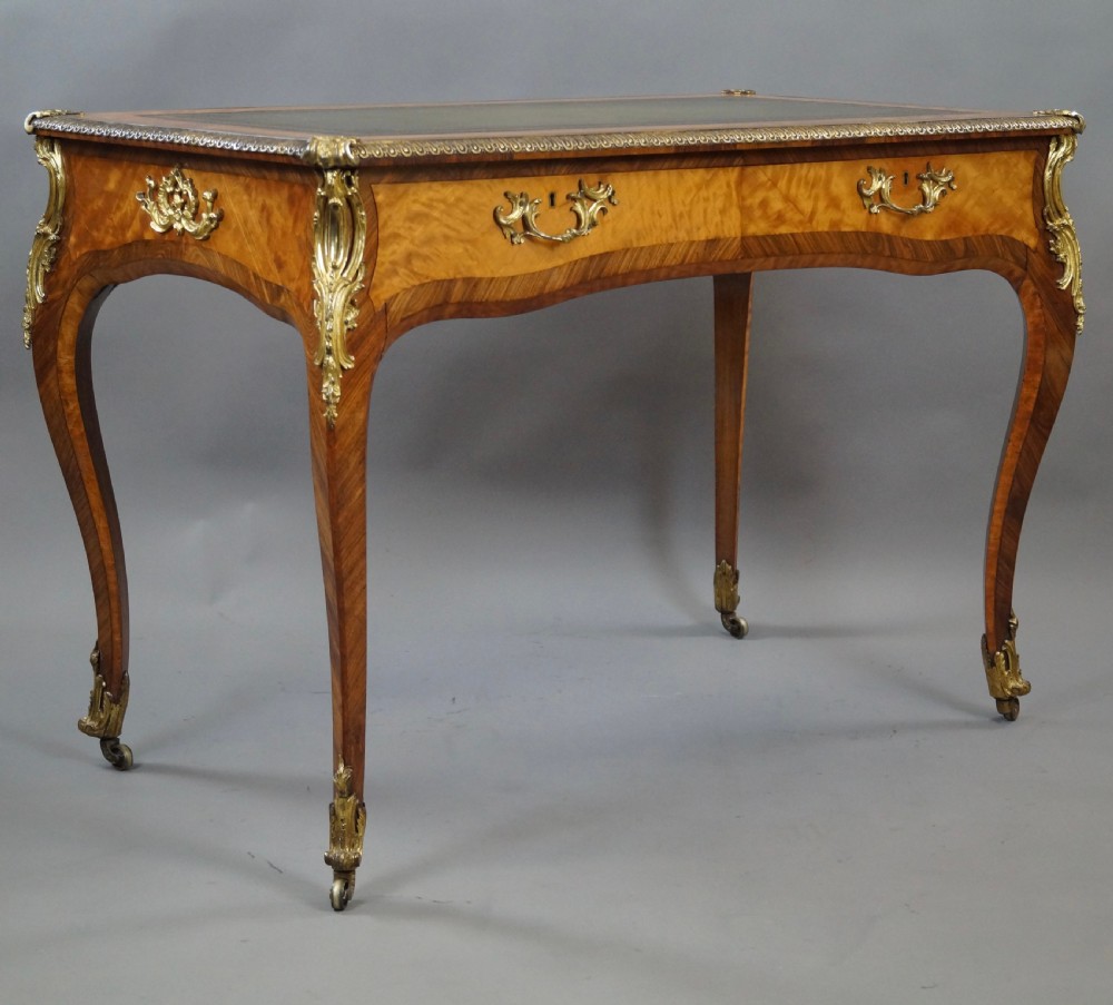 A pair of Louis XV style bureau plat writing desks featuring satinwood marquetry, green leather tops, cabriole legs, and elaborate gilt-bronze mounts. View VI